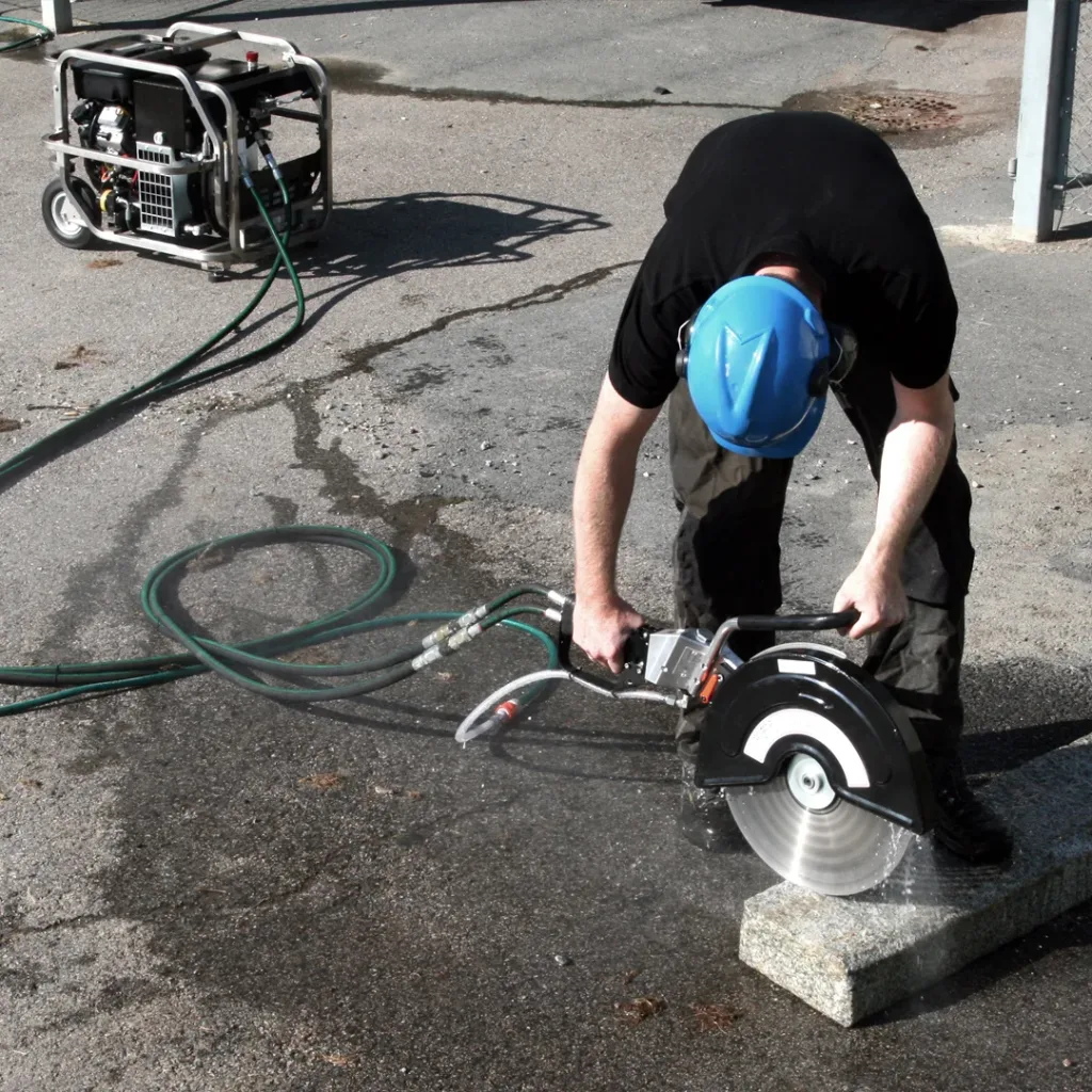 Arbeider som kutter med hydraulisk kappsag hvor et hydraulisk aggregat brukes som strømkilde