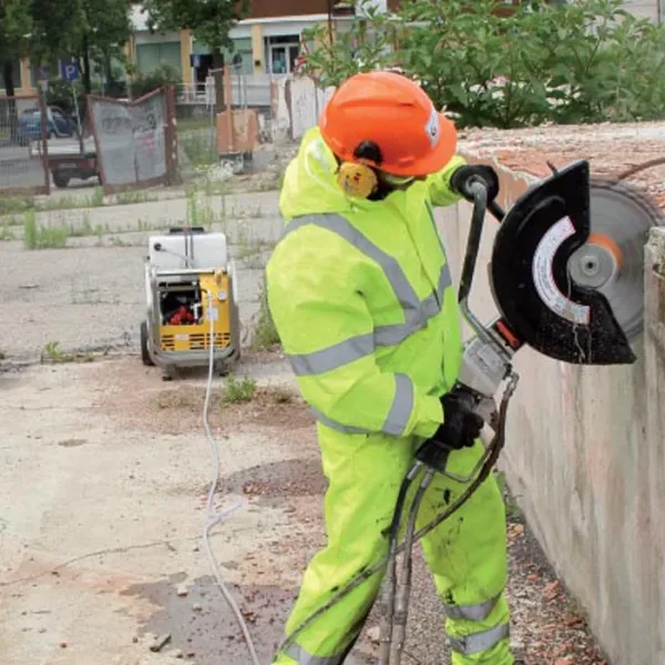 doa-kappmaskin-1700 En arbeider som kutter i betong med en hydraulisk kappsag, hvor doa hydraulikkaggregat brukes som strømkilde