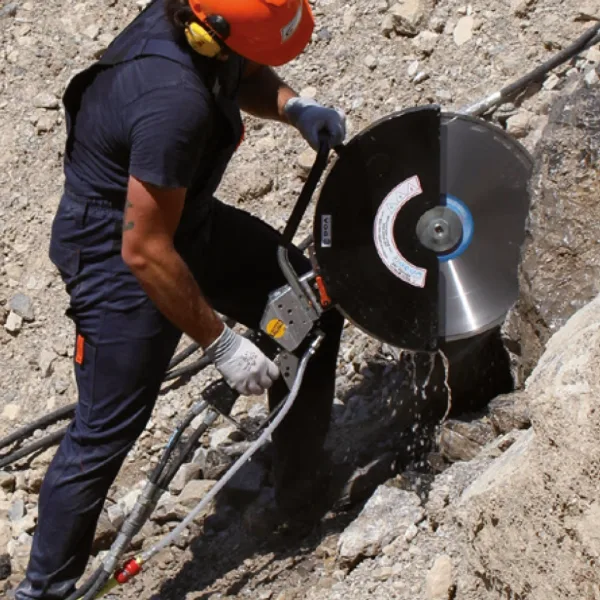 Arbeider som kutter stein med Doa DC20, DC22 hydraulisk kappesag