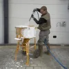 Arbeider som påfører cretebeater skum på betongblander