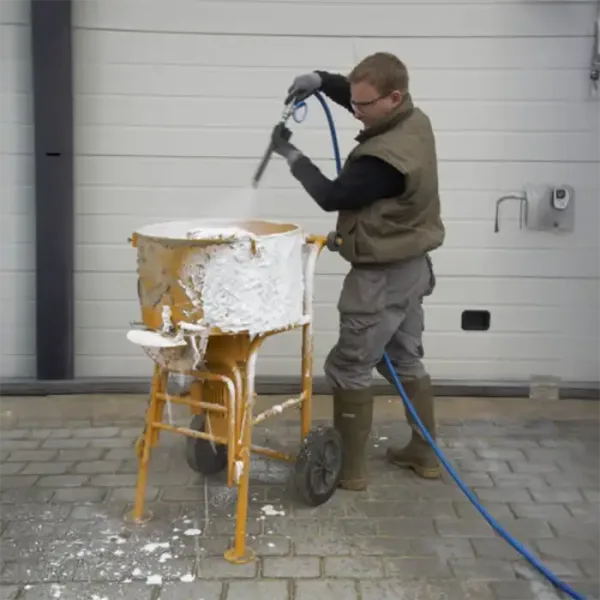 Arbeider som påfører cretebeater skum på betongblander
