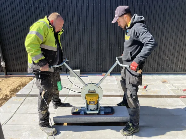 AL-Boddy Lay 200-2 To arbeidere som legger beleggningsstein ved hjelp av Boddy Lay vakkumløfter