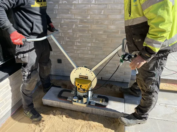 AL-Boddy Lay 200-6 To arbeidere som legger beleggningsstein ved hjelp av Boddy Lay vakkumløfter