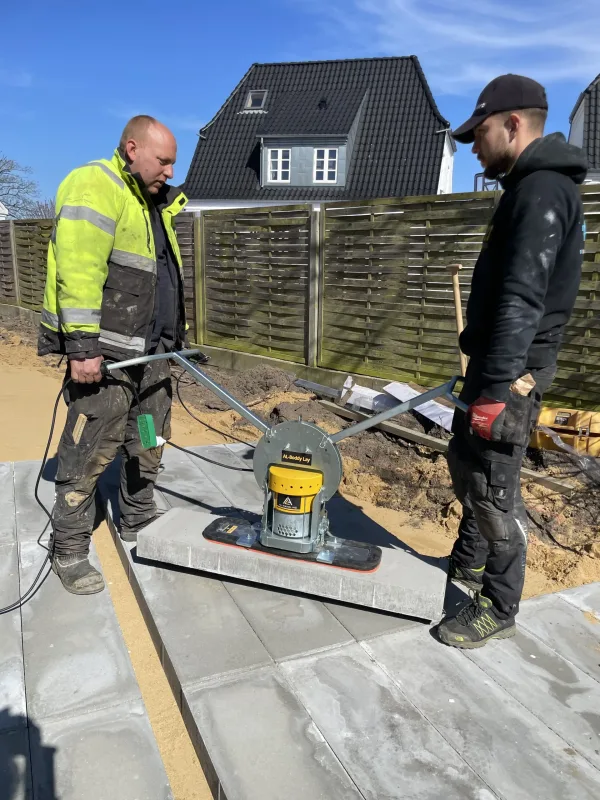 AL-Boddy Lay 200 To arbeidere som legger beleggningsstein ved hjelp av Boddy Lay vakkumløfter