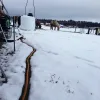 Frostfri vannslange ligger på bakken og har smeltet snøen rundt seg