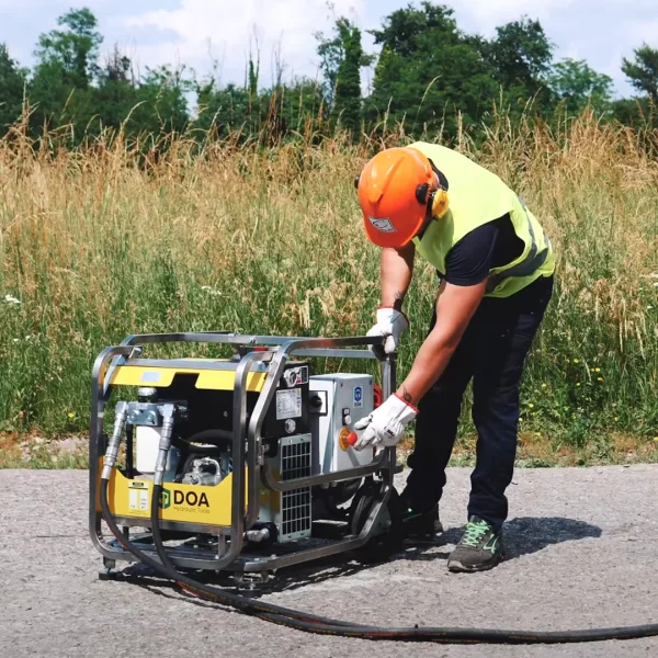 Arbeider som starter det hydrauliske aggregatet super raptor E fra Doa, med elektrisk motor