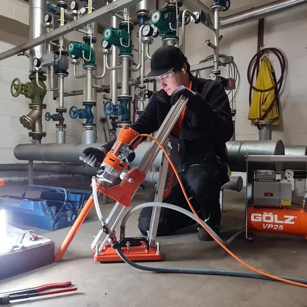 Arbeider som bruker kjerneborstativ SD160 og kjernebormaskin med et mindre borr